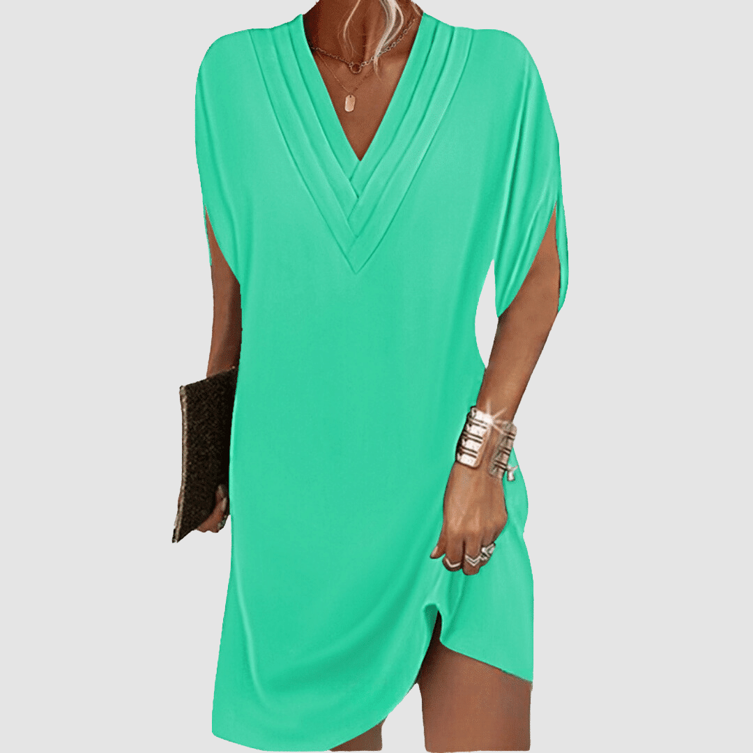Bright turquoise half-sleeve dress with elegant V-neck, presented against a light grey backdrop.