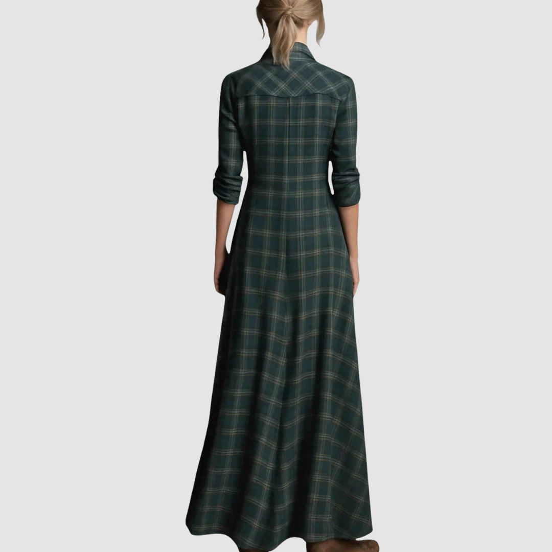 Back view of a plaid long dress with a fitted bodice and flared hem, worn by a model with a ponytail, studio background.