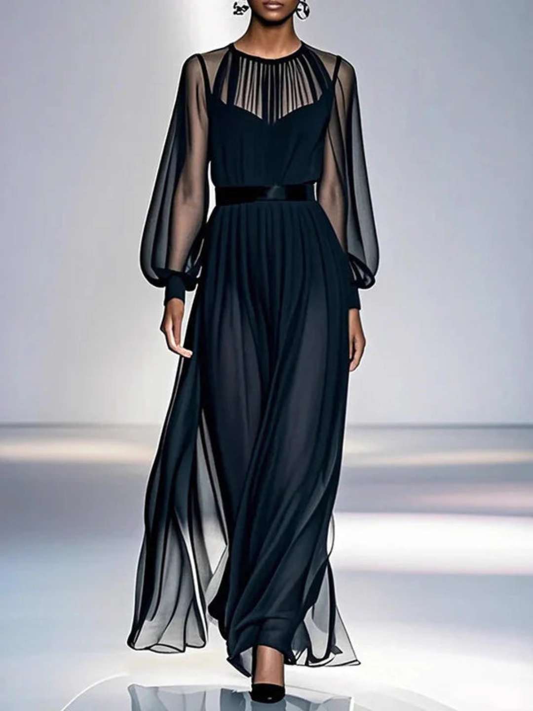 Elegant black dress with sheer long sleeves and flowing silhouette, in a studio setting.