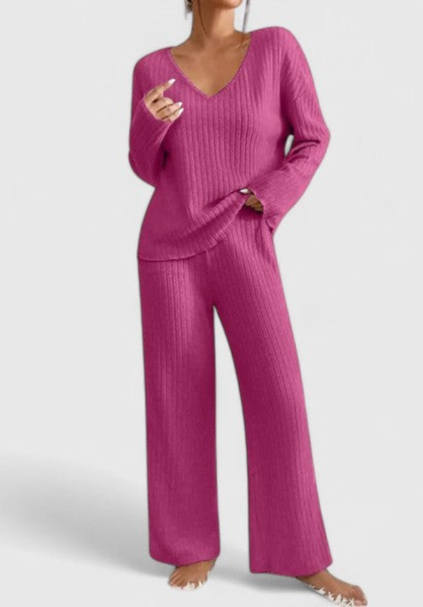 Pink ribbed V-neck long-sleeve top and matching wide-leg pants in studio setting.