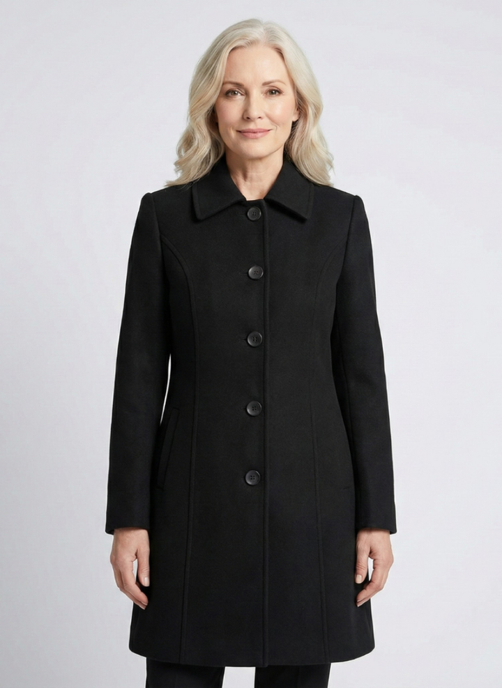 Front view of black elegant coat worn by a person in a light studio setting.