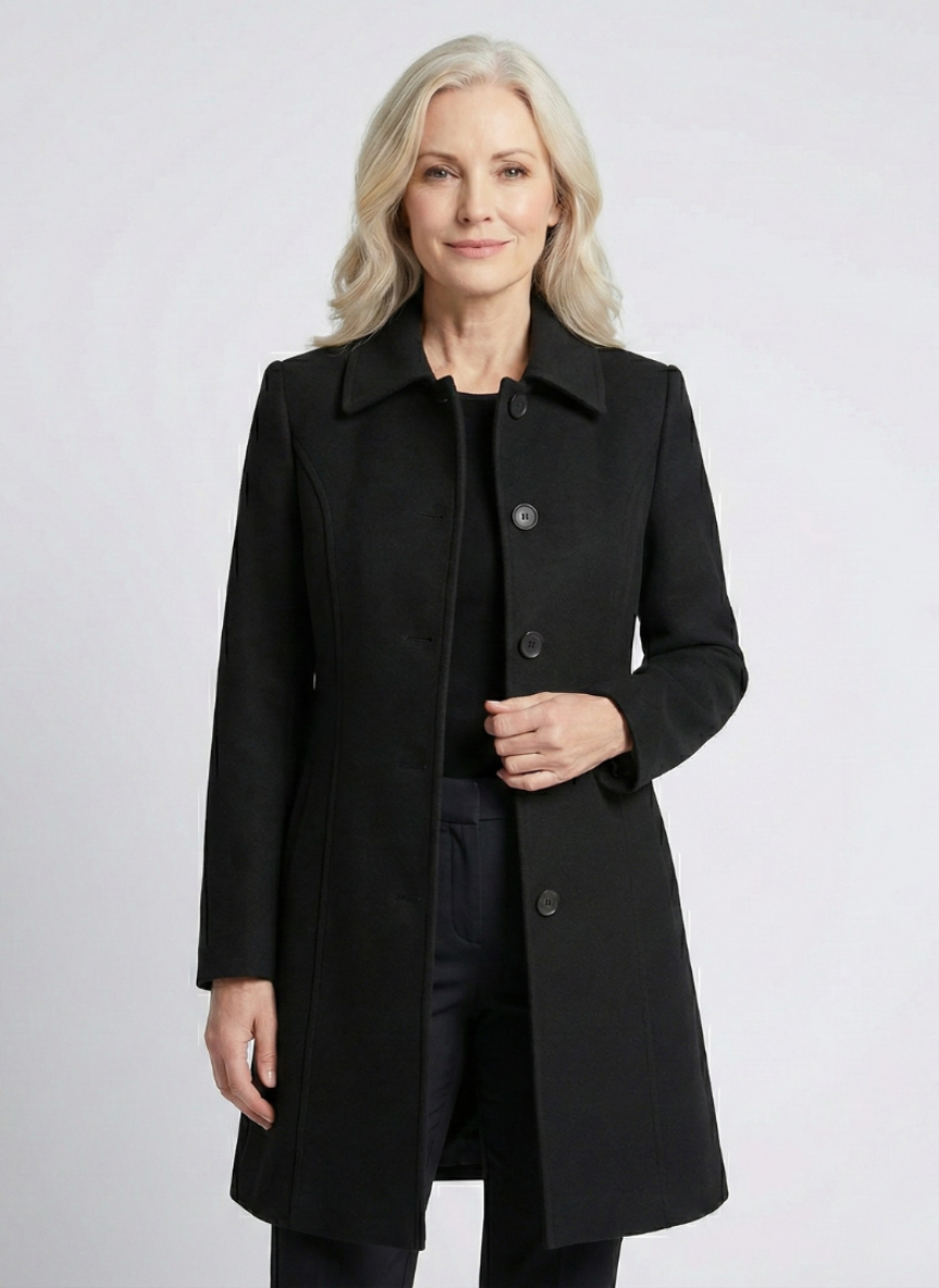 Black elegant coat worn by a person against a light studio background.