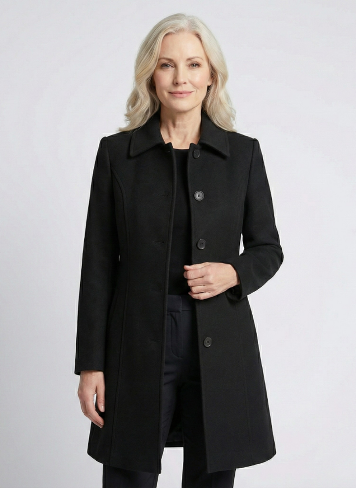 Black elegant coat worn by a person against a light studio background.