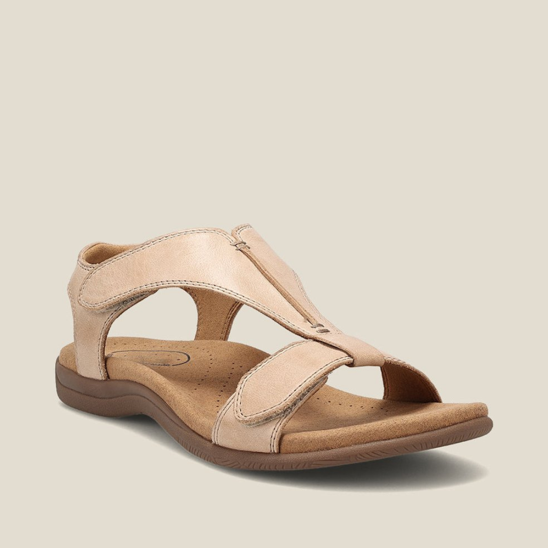 Beige orthopedic sandal with soft footbed, secure straps, and minimalist look on light background.