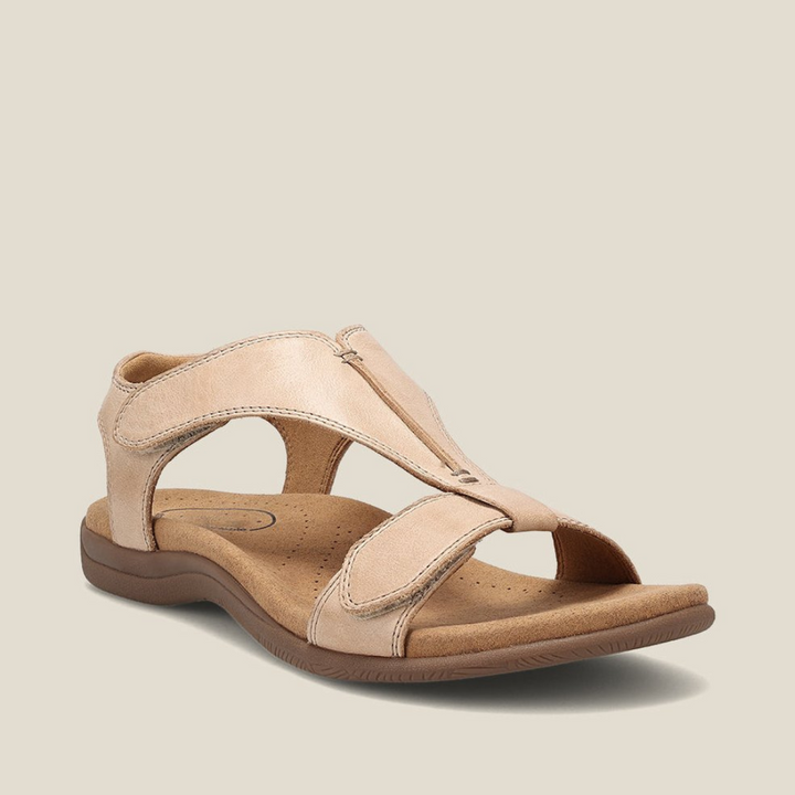 Beige orthopedic sandal with soft footbed, secure straps, and minimalist look on light background.