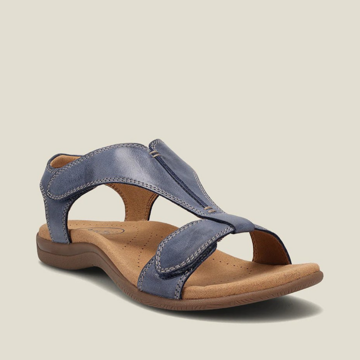 Blue orthopedic sandal showcasing cushioned footbed, durable straps, and modern design on beige backdrop.