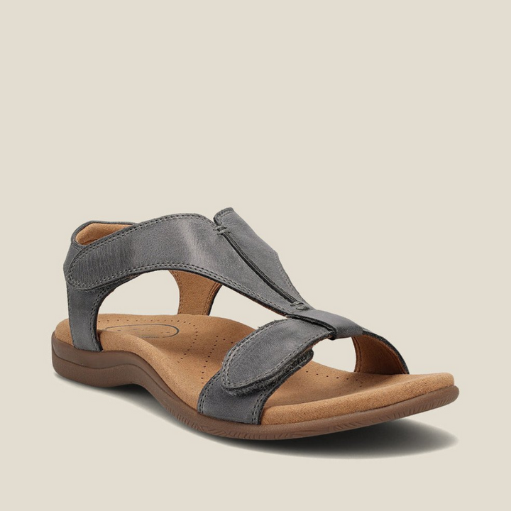 Gray orthopedic sandal with ergonomic footbed, adjustable straps, and sleek look on pale background.