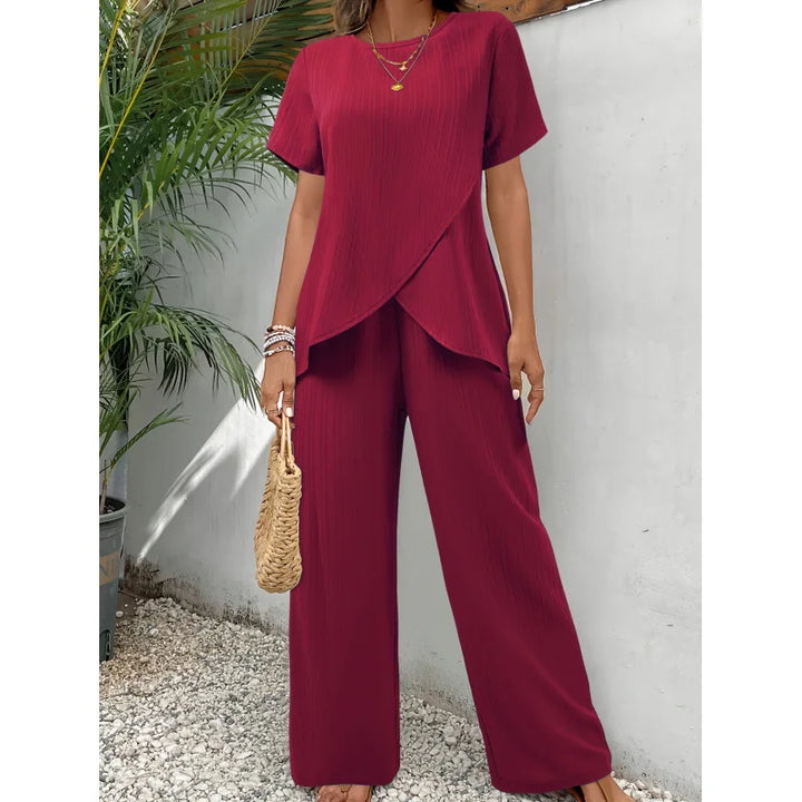 Red two-piece set featuring a soft, flowing short-sleeve top and wide-leg pants, modeled outdoors with tropical plants.