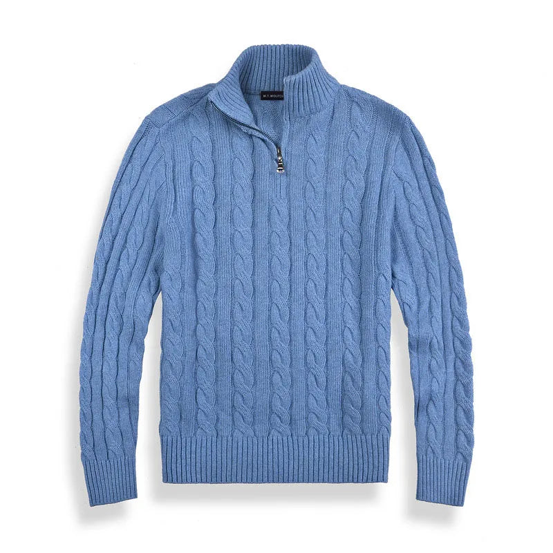 Blue cable-knit sweater with half-zip design, laid flat against a white background in a studio setting.