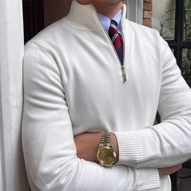 Close-up of white half-zip sweater with shirt and tie, featuring a watch, near a door and brick wall.