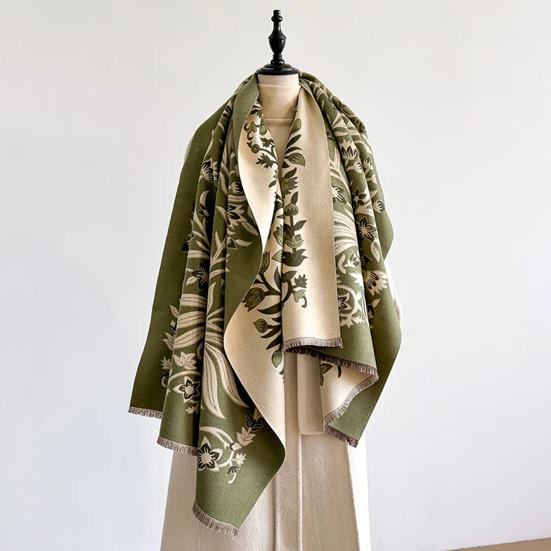 Green and cream botanical scarf on a mannequin against a plain wall.
