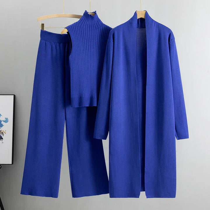 Bright blue three-piece set featuring sleeveless ribbed top, wide-leg pants, and long open cardigan on hangers in a studio setting.
