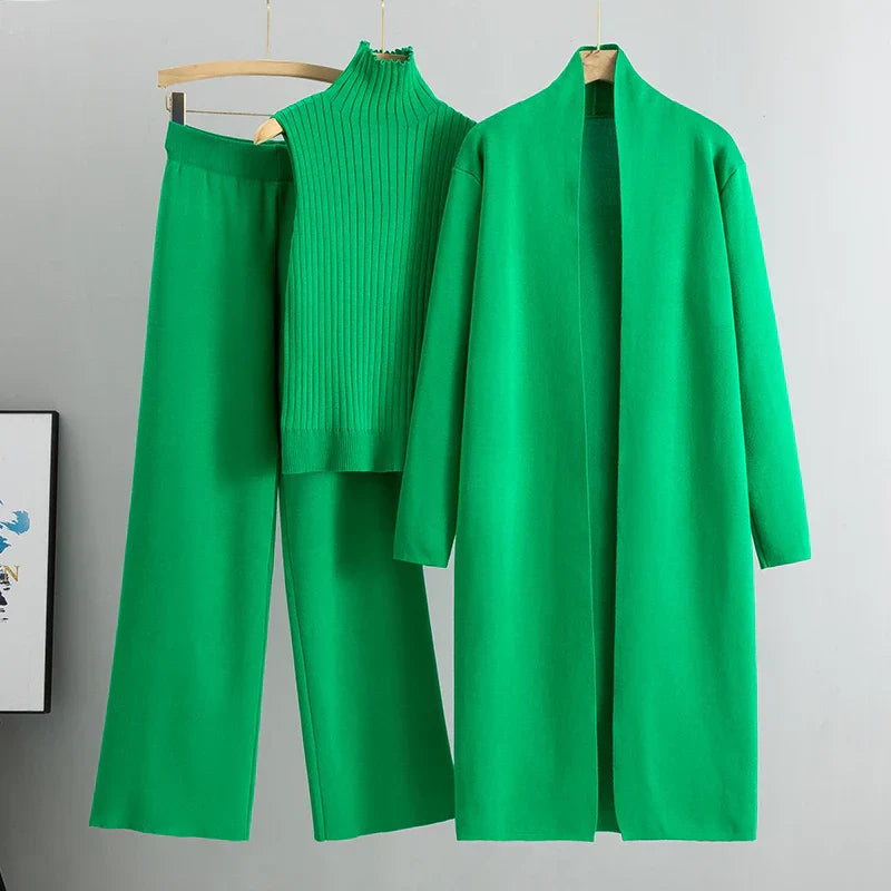 Vibrant green three-piece set with sleeveless ribbed top, wide-leg pants, and long open cardigan on hangers in a studio setting.