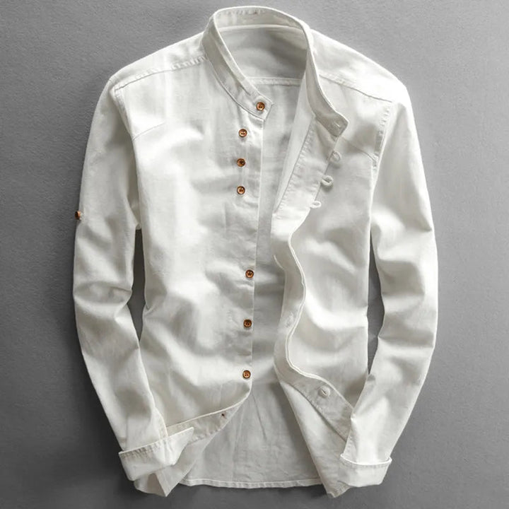 White long-sleeve shirt with a stand collar and brown buttons, displayed on a light gray studio background.