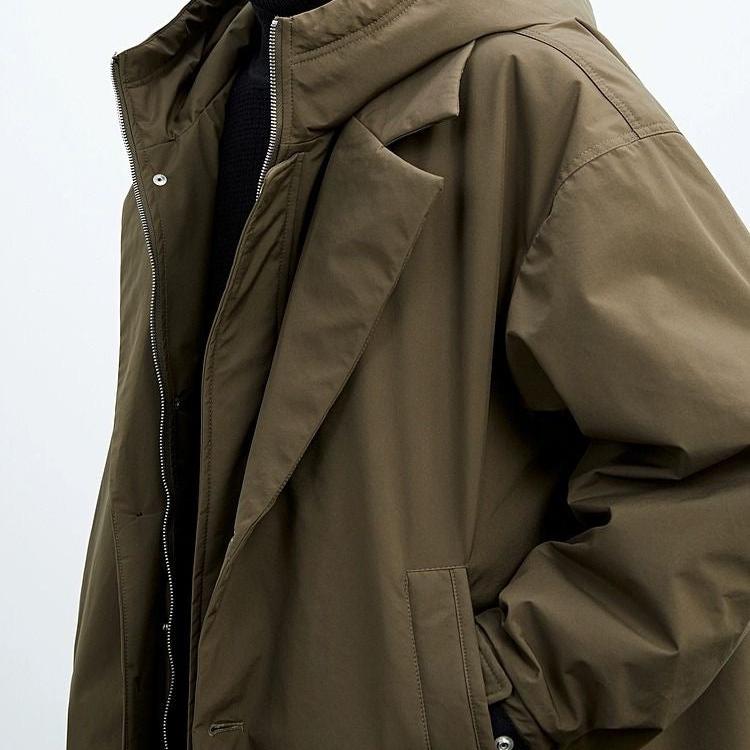 Close-up of a brown long coat with a hood and side pocket in a studio.