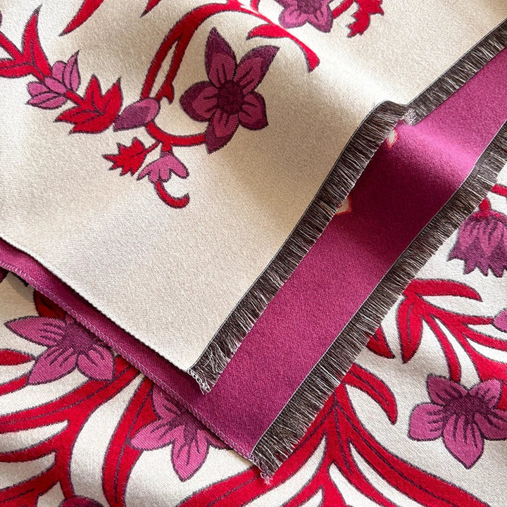 Close-up of red and cream floral patterned scarf with fringed edges.