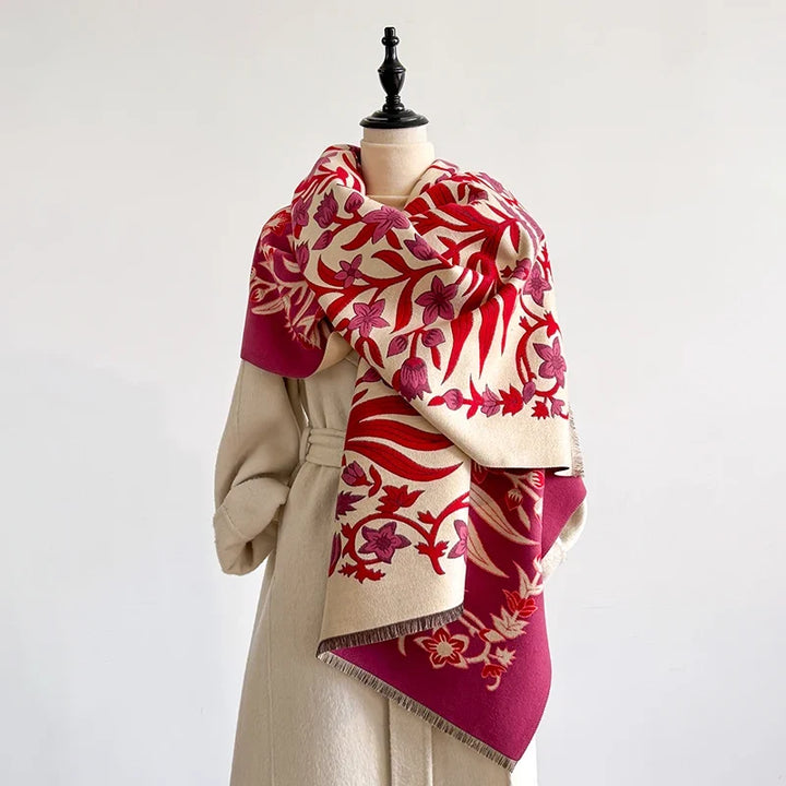 Red and cream botanical scarf wrapped around a mannequin in a studio setting.