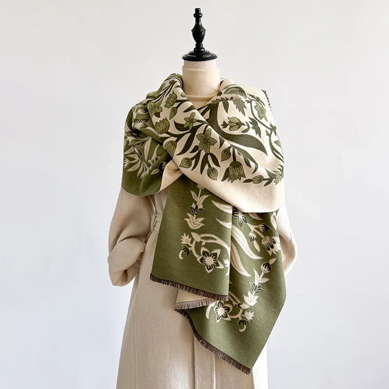 Green botanical scarf with intricate design wrapped around a mannequin.