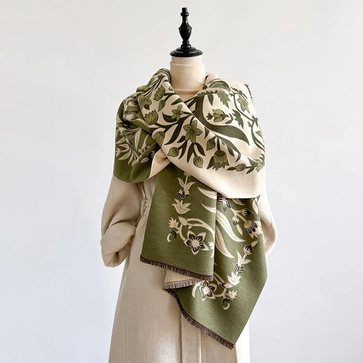 Green botanical scarf with intricate design wrapped around a mannequin.