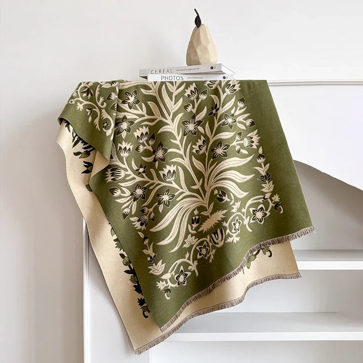 Green botanical scarf with floral design draped over a white shelf.