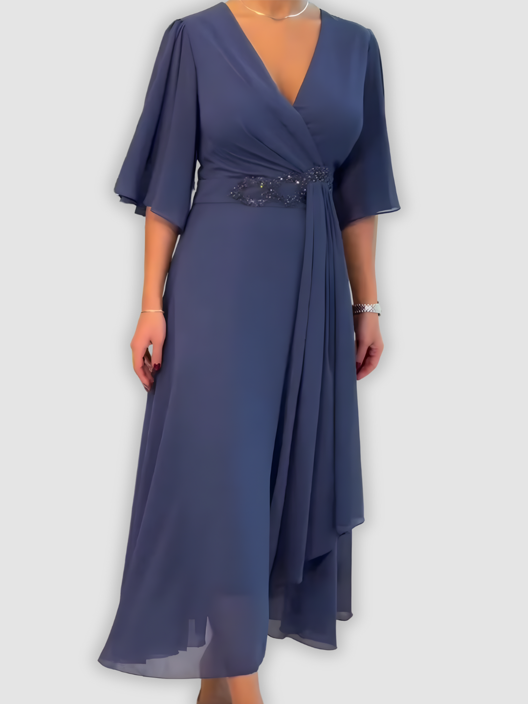 Luxurious dark blue maxi dress with flowing fabric and beaded waistband in a minimalist studio setting.