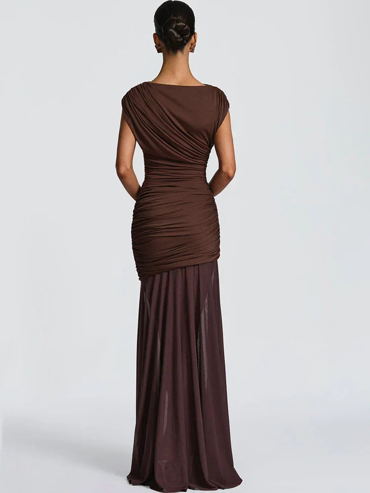 Back view of elegant brown gown with ruched top and flowing skirt, worn in a studio setting.