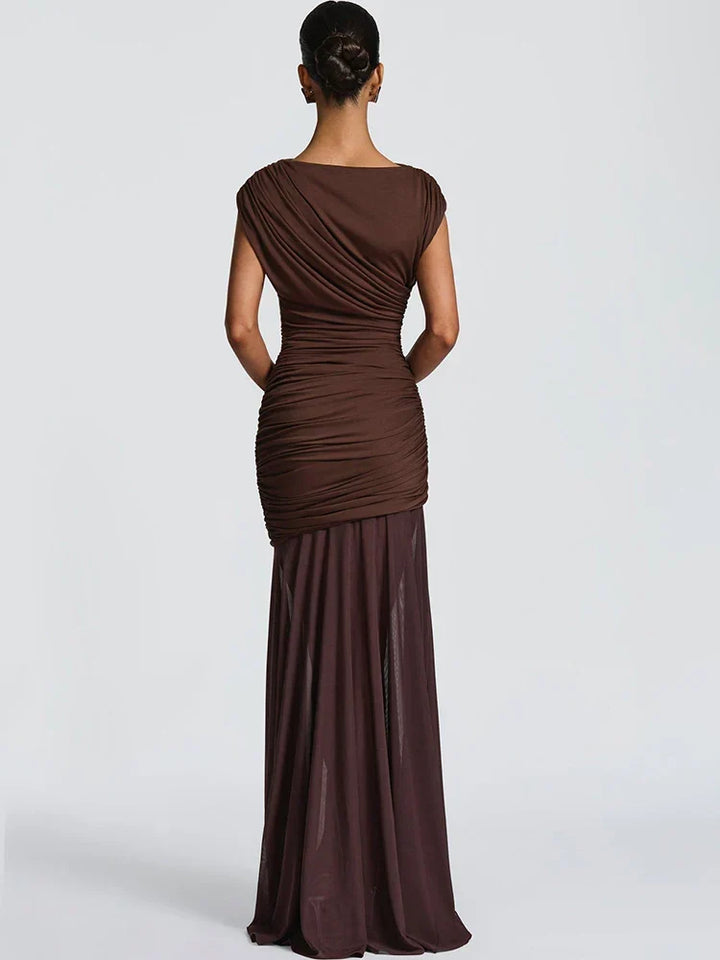 Back view of elegant brown gown with ruched top and flowing skirt, worn in a studio setting.