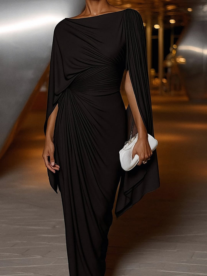 Sophisticated black pleated drape maxi dress with flowing design, paired with a white clutch in a modern indoor setting.