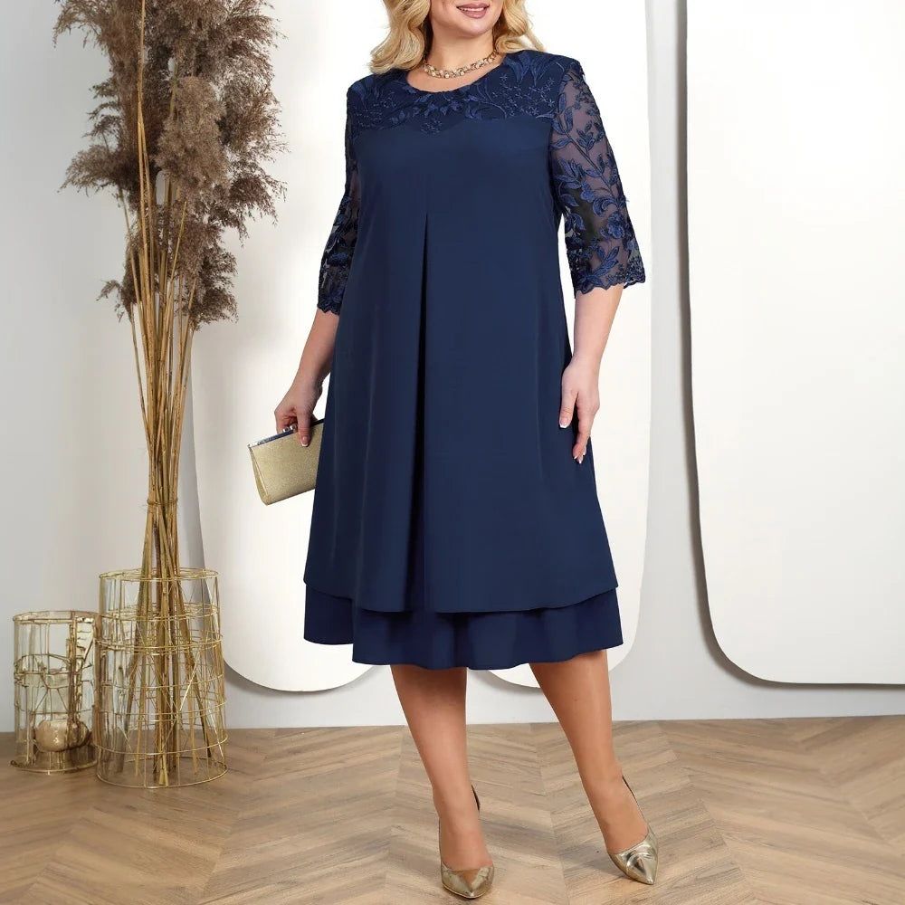 Classic navy midi dress with elegant lace sleeves, gold shoes, and clutch, displayed in a contemporary indoor setting.