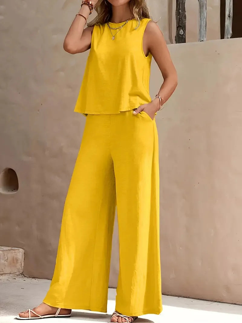 Yellow sleeveless two-piece set with wide-leg pants, styled outdoors against a beige wall.