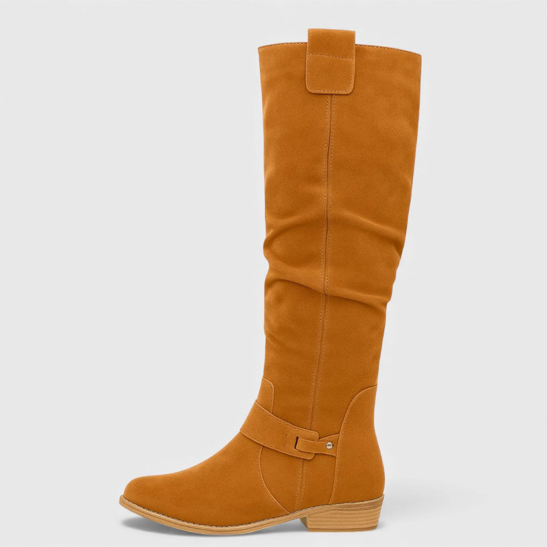 Single orange knee-high boot with buckle detail on a wooden heel, studio background.