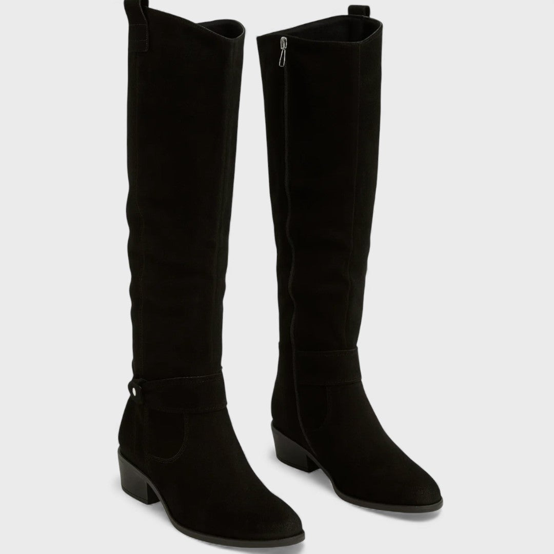 Pair of black knee-high boots with buckle detail, zipper, and heels, studio background.