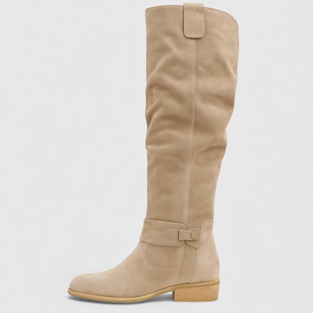 Single tan knee-high boot with buckle detail on a wooden heel, studio background.