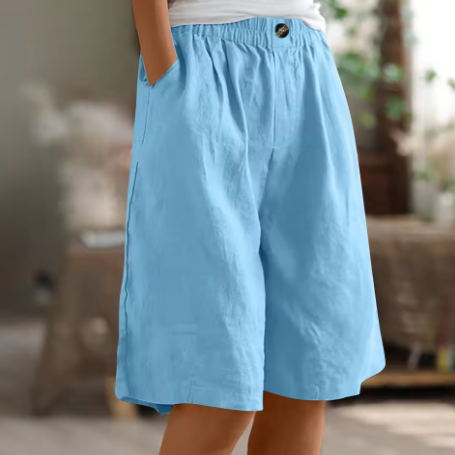 Light blue comfort shorts with elastic waistband and handy pockets in a cozy indoor setting.
