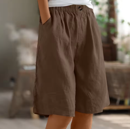 Brown comfort shorts featuring a stretchy waistband and pockets, showcased in a soft-lit indoor setting.