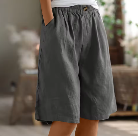 Charcoal gray comfort shorts featuring an elastic waistband and pockets, showcased in a warm indoor environment.
