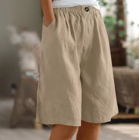 Khaki comfort shorts with elastic waist and pockets, showcased in a softly lit, warm indoor environment.