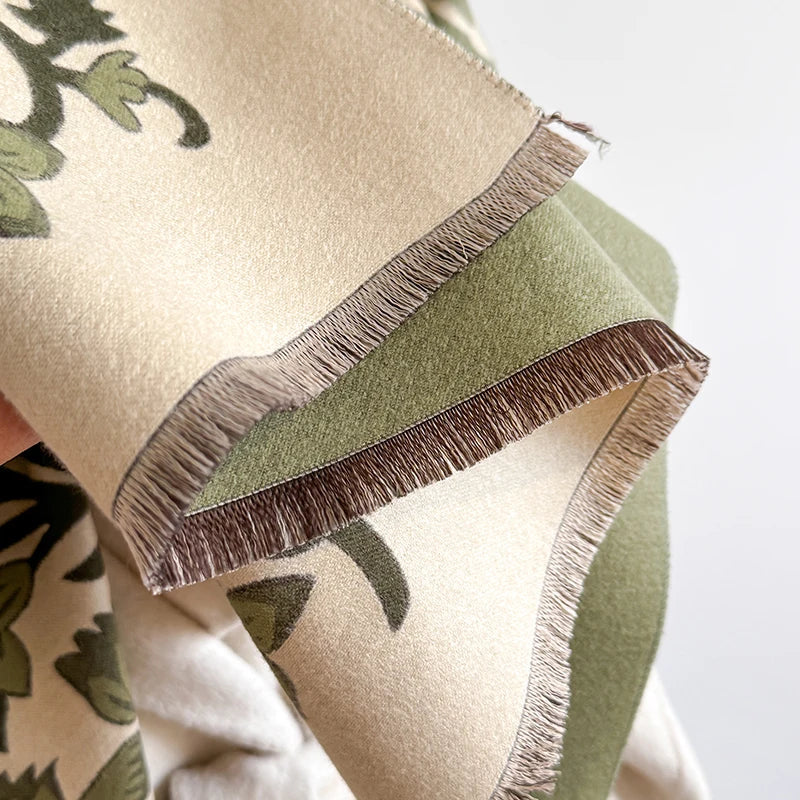 Close-up of green and cream scarf edge with detailed floral patterns.