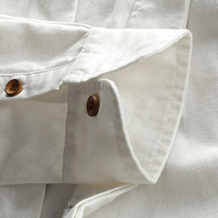 Close-up of white shirt cuffs and brown buttons, showcasing the soft fabric texture.