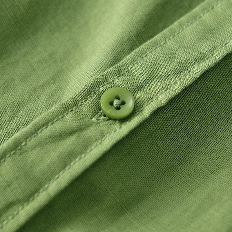 Close-up of green linen shirt button and stitching.