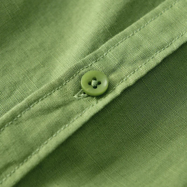 Close-up of green linen shirt button and stitching.