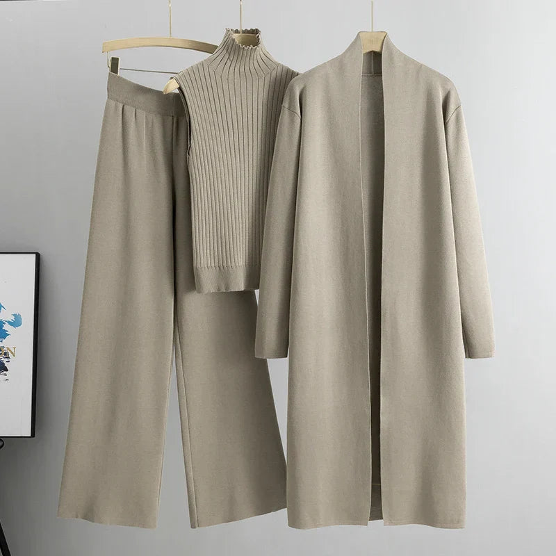 Taupe three-piece set featuring sleeveless ribbed top, wide-leg pants, and a long open cardigan on hangers in a studio setting.