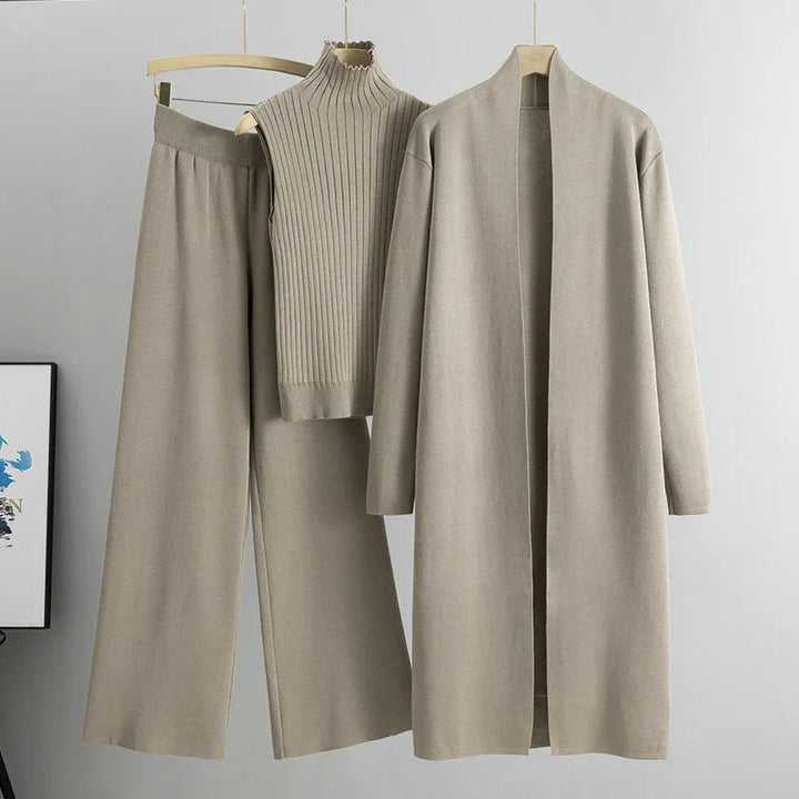 Taupe three-piece set featuring sleeveless ribbed top, wide-leg pants, and a long open cardigan on hangers in a studio setting.