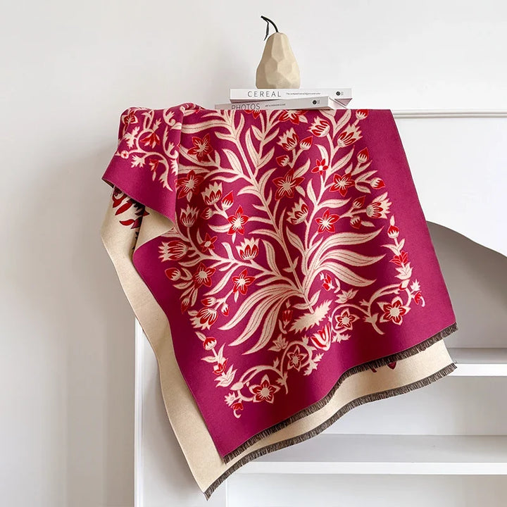 Red botanical scarf with intricate design draped over a white shelf.