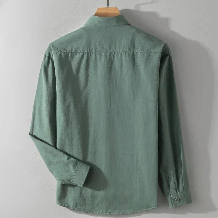 Back view of forest green shirt with long sleeves on wooden hanger, gray studio background.