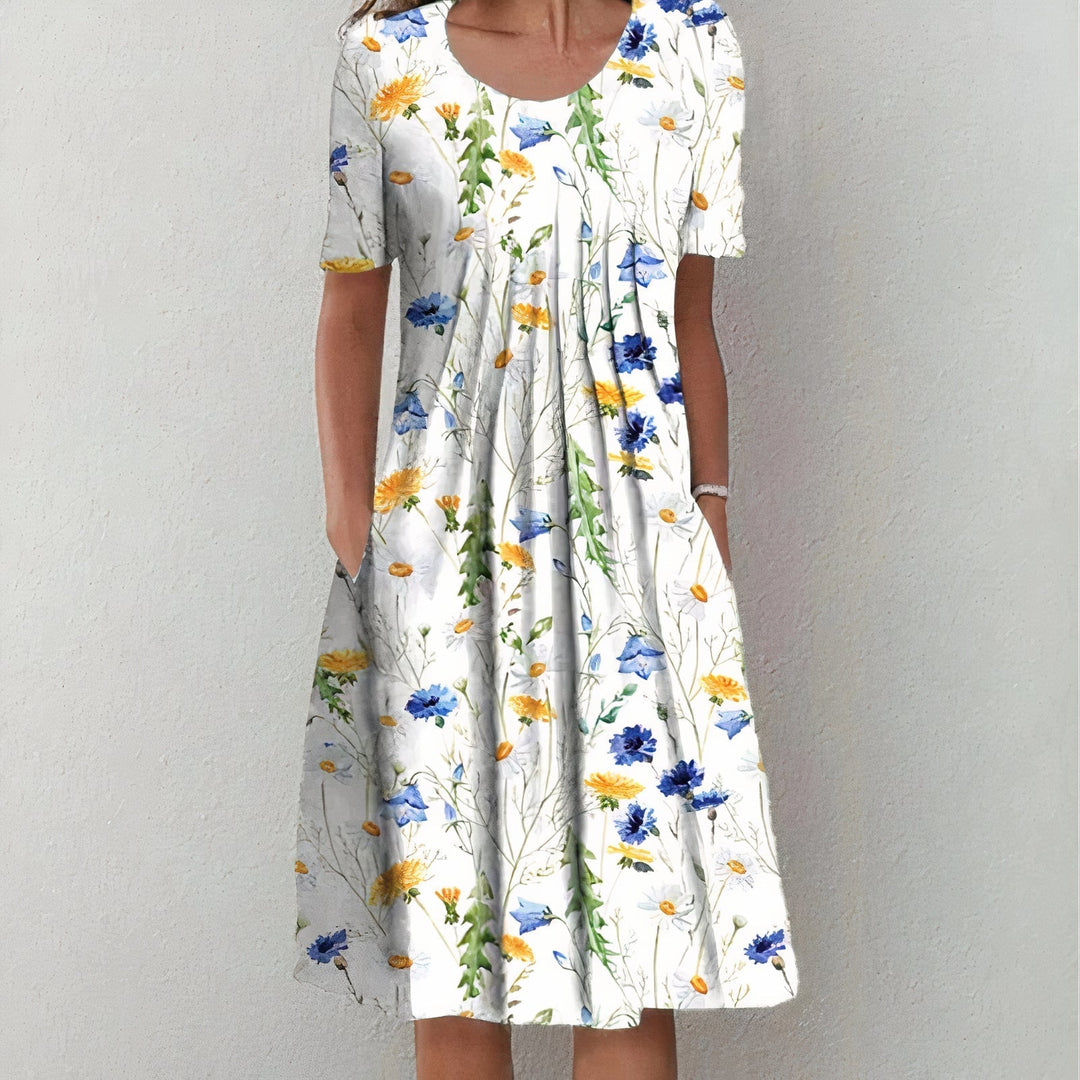White dress with blue and yellow floral pattern in a studio setting.
