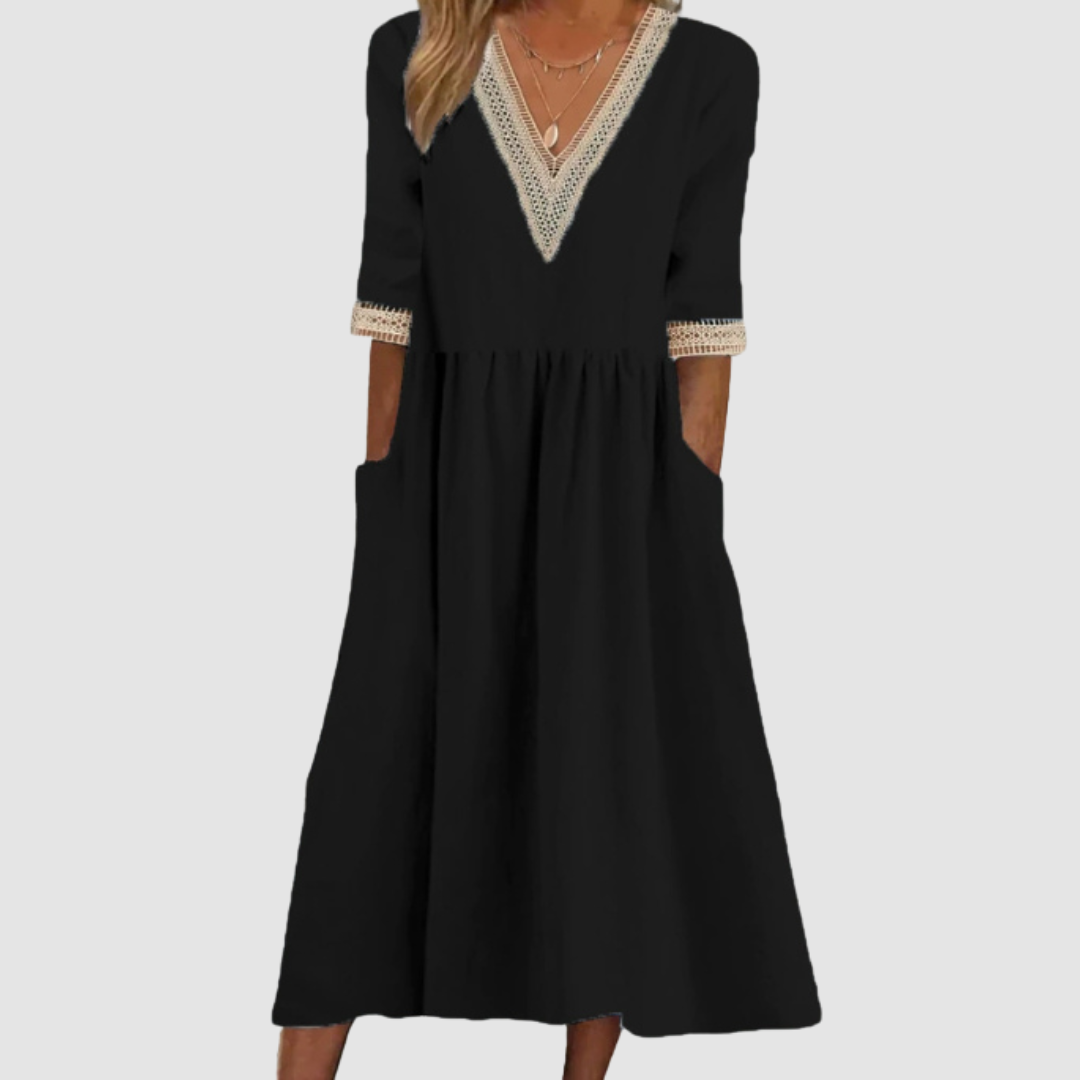 Black mid-length dress with crochet trim neckline and sleeves, styled in a studio on a light gray background.