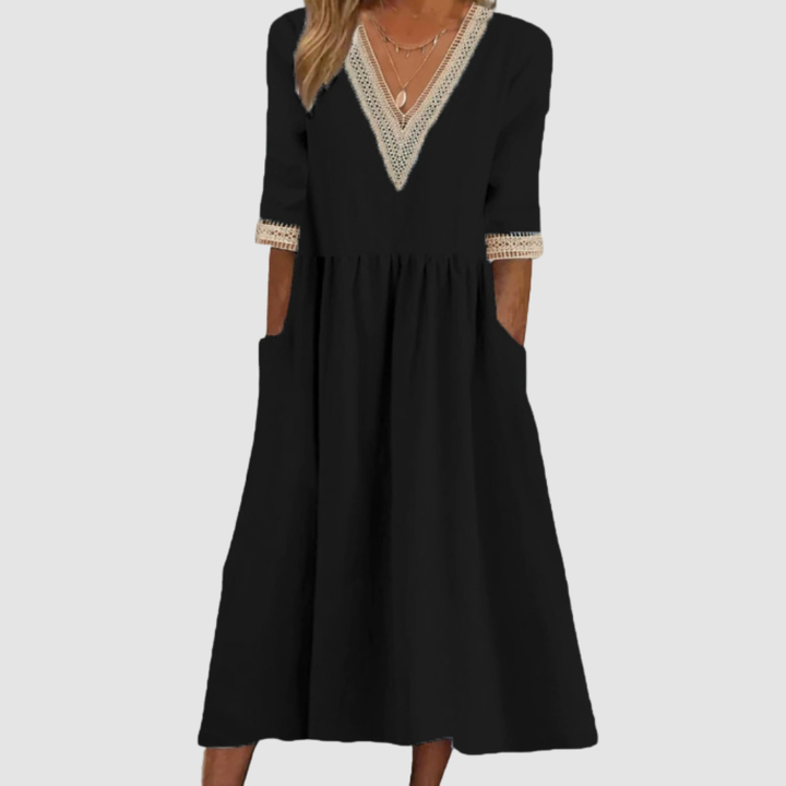 Black mid-length dress with crochet trim neckline and sleeves, styled in a studio on a light gray background.