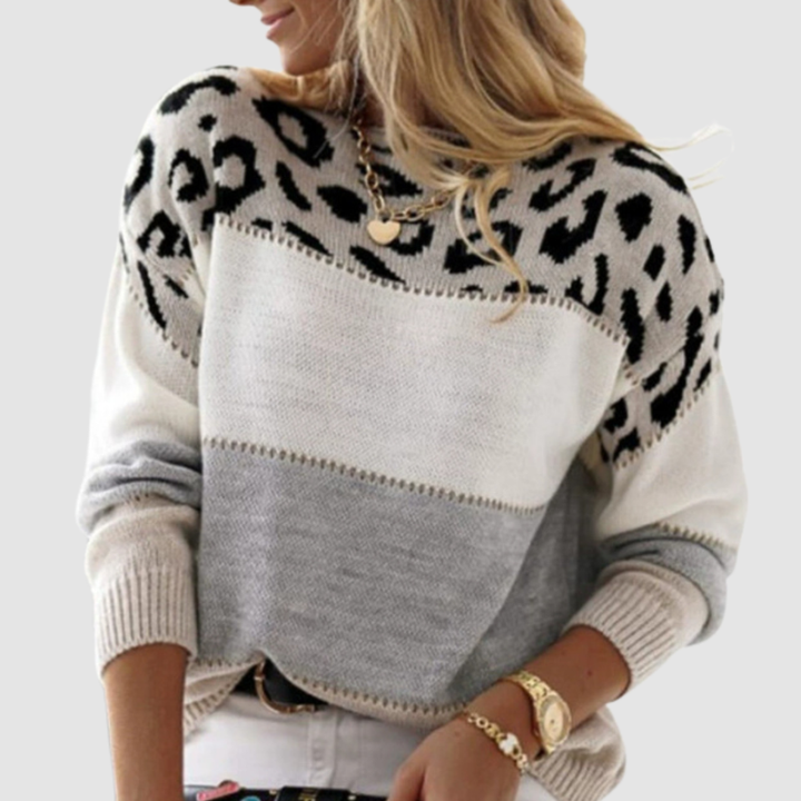 Elegant jumper with animal print on shoulders, gray and white block design, worn by model in studio.