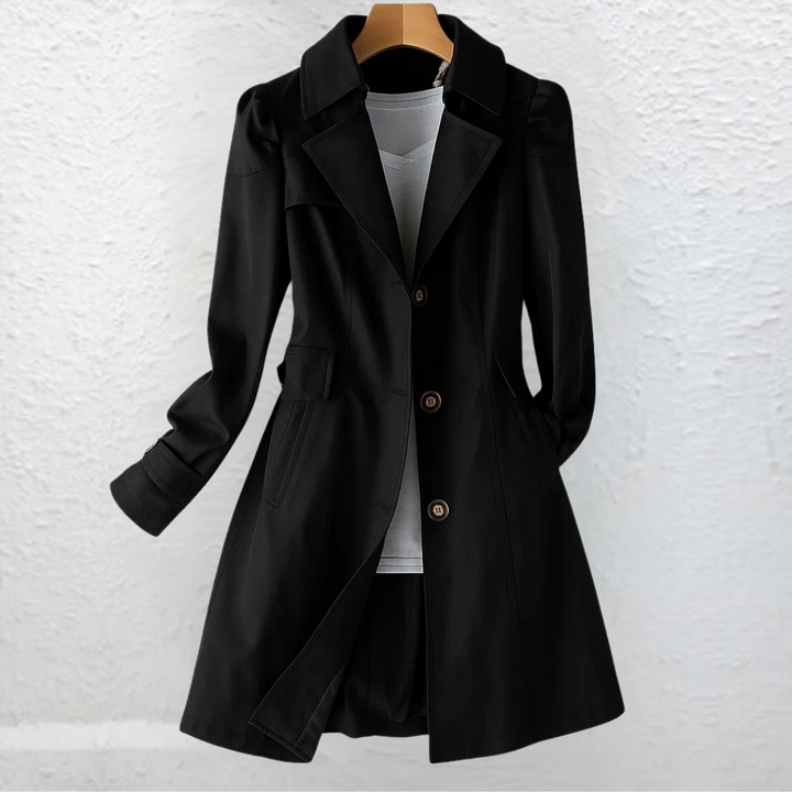 Black coat on a hanger, featured against a textured white wall.